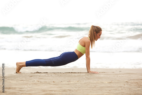 young woman doing yoga at the beach © mimagephotos