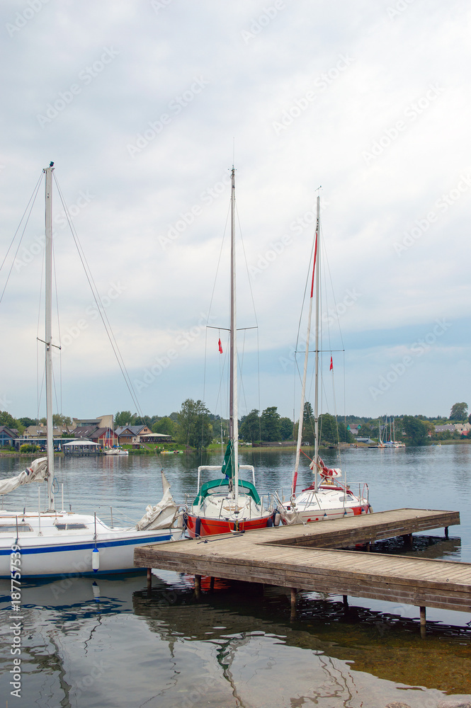 Three catboats docked on wooden quay on lake Galve in Trakai, Lithuania