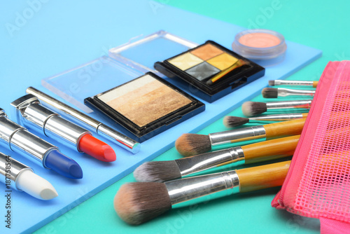 Content of cosmetic bag. Lipstick, eye shadows, brushes for makeup on top view copyspace 