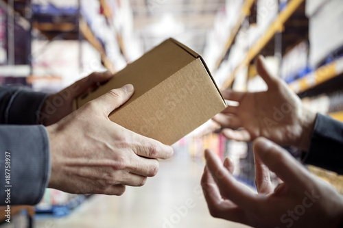 Worker with package in a distribution warehouse