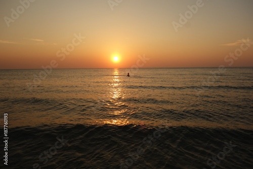 Girl swimming at sunset