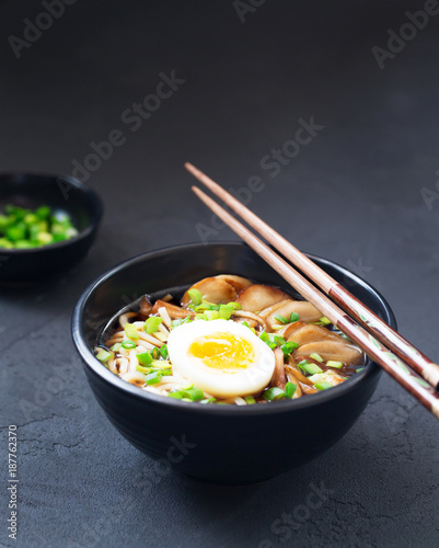 Ramen soup with mushrooms, vertical, black background