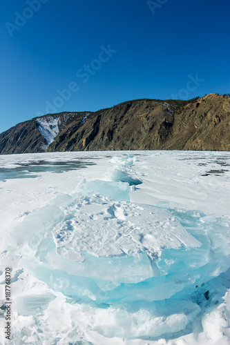 Pure transparent ice hummocks of Lake Baikal through the sun is shining in the sunset