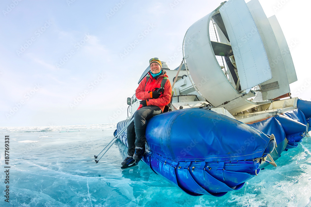 Naklejka premium girl sits on the board hovercraft ice winter lake Baikal