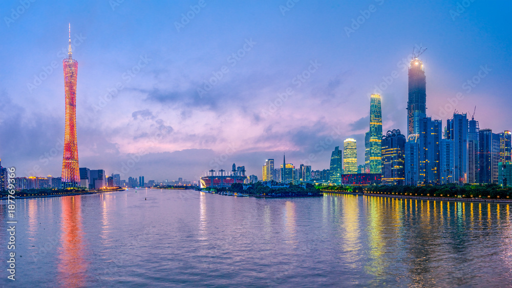 Guangzhou, China skyline on the river at dusk.
