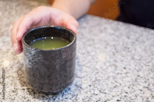 Woman hand hold Hot Green Tea cup