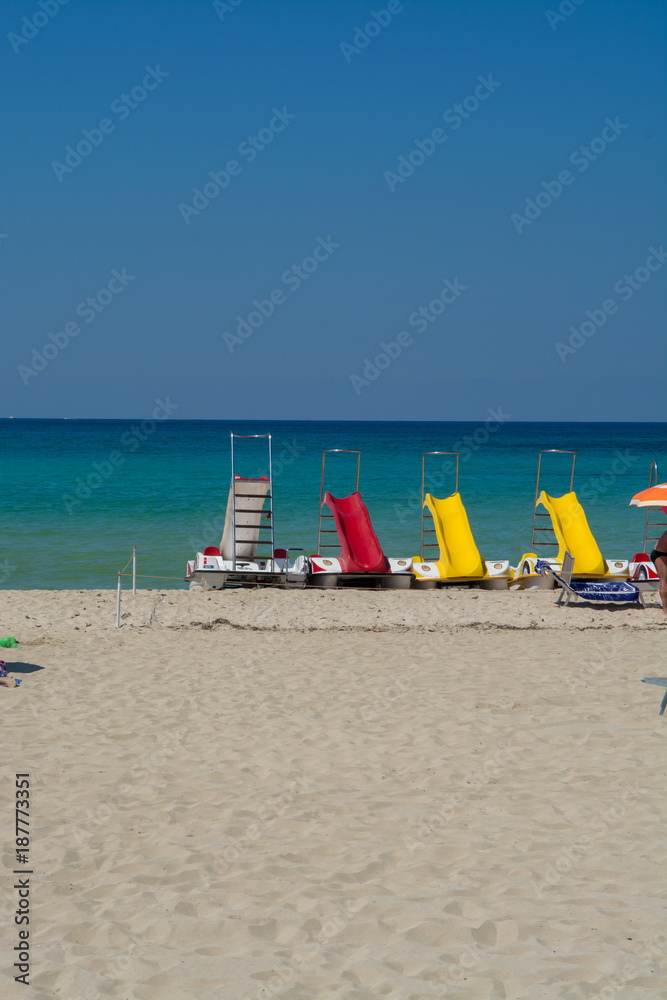 Pedal-boats with water slides on the white sandy beach, beach summer vacation, sea vacation Pedal-boats with water slides on the white sandy beach, beach summer vacation, sea vacation