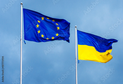 The flag of the European Union and Ukraine, against the background of the sunny sky.