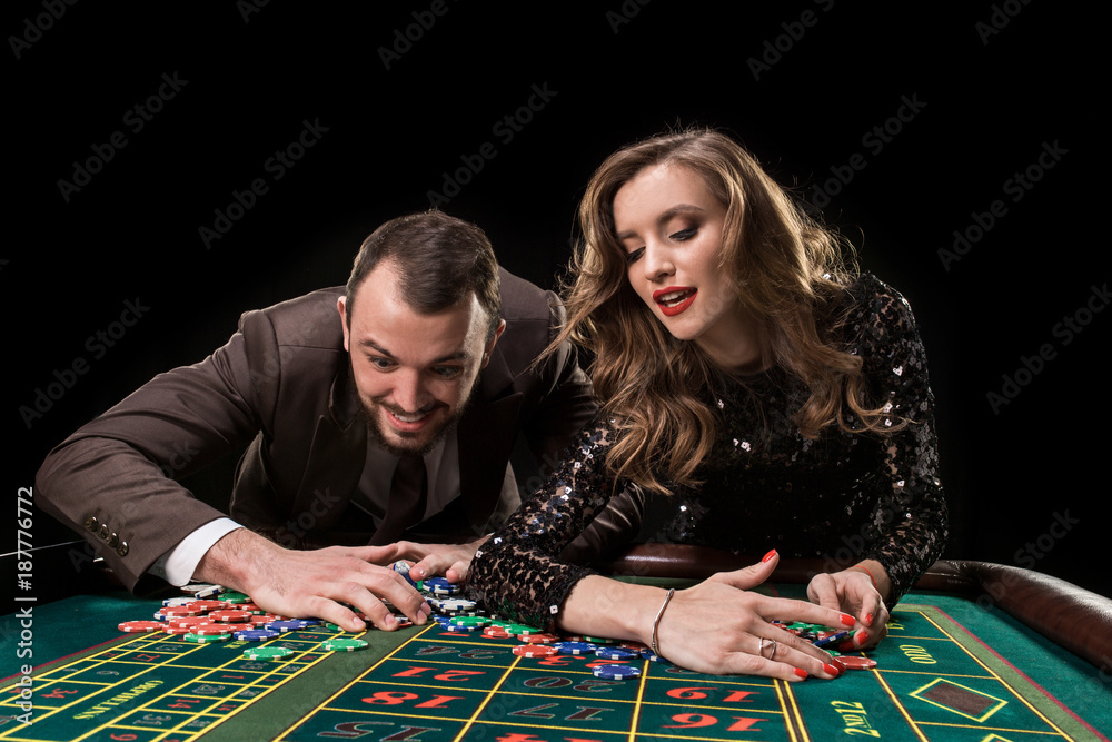 Man and woman playing at roulette table in casino Man and woman playing at roulette table in casino