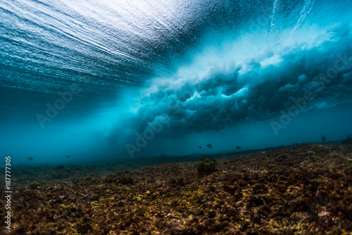Underwater view of an ocean wave breaking over coral reef