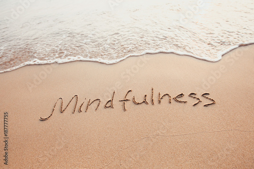 Fototapeta mindfulness concept, mindful living, text written on the sand of beach