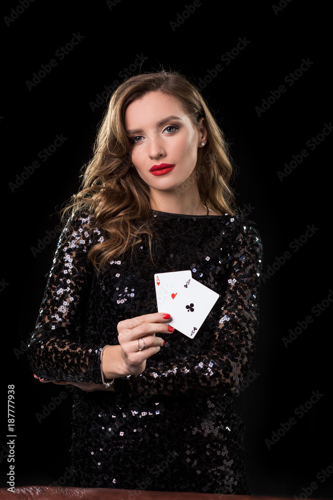 Young woman holding playing cards against a black background Young woman holding playing cards against a black background