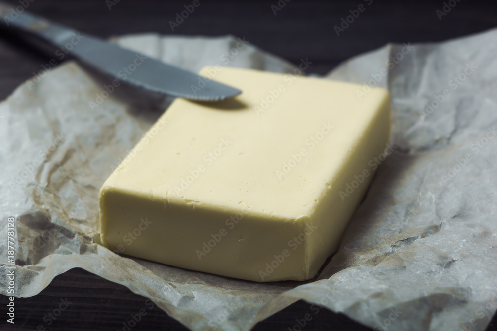 Butter with a knife on the kitchen table. Breakfast.