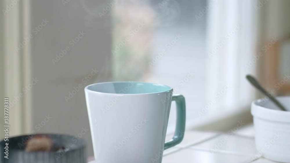 Tracking shot of teal mug filled with steaming hot water Tracking shot of teal mug filled with steaming hot water
