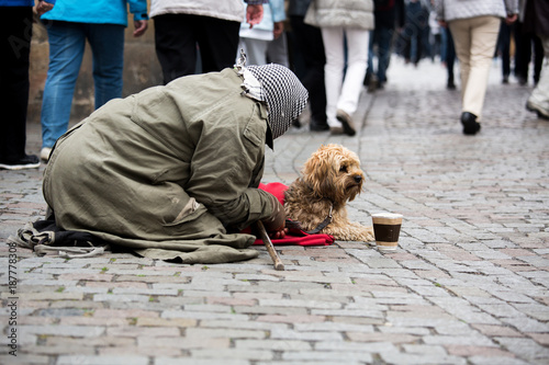 Photography A beggar with a dog on the street of a European city
