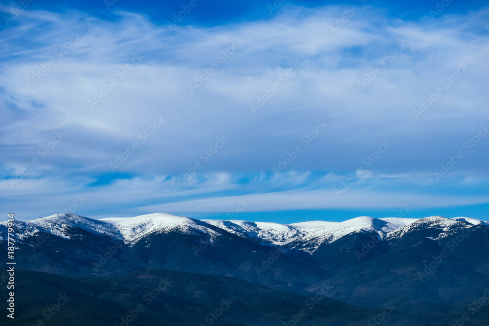 Mountain snow peak, beautiful natural winter backdrop. Ice top of the hill, blue sky background. Alpine landscape.