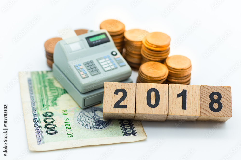 Cashier machine with coins around it, and wood block 2018. Image use for shopping, business concept. Cashier machine with coins around it, and wood block 2018. Image use for shopping, business concept.