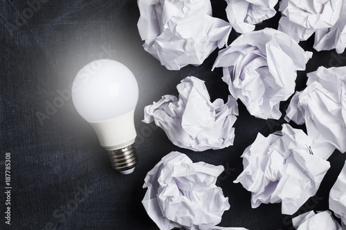 Inspiration and imagination concept. lightbulb with white crumpled paper documents