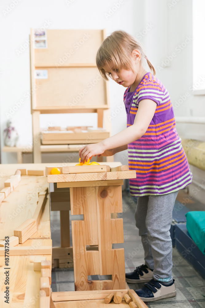  girl   playing  with wooden puzzle. - obrazy, fototapety, plakaty 