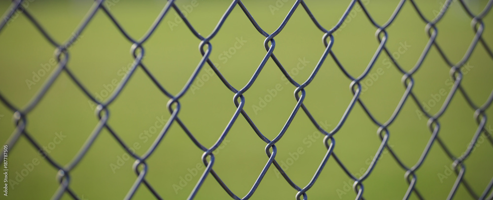Steel wire mesh fence with green blurred background. Close up view with details. Steel wire mesh fence with green blurred background. Close up view with details.