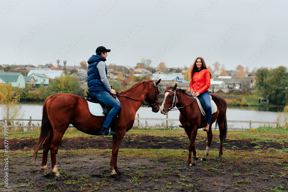 young couple in a Russian village with horses, riding young couple in a Russian village with horses, riding