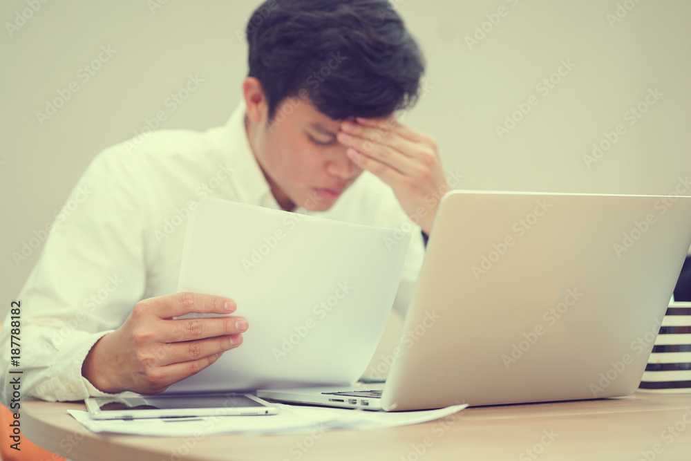 close up employee man headache with hard working after reading paper project form , office syndrome concept close up employee man headache with hard working after reading paper project form , office syndrome concept