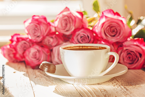 White cup of coffee for valentine or romantic morning with pink roses