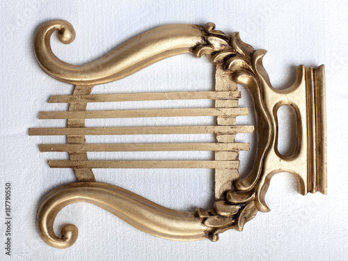 Gold colour antique mouth harp, white background  photo