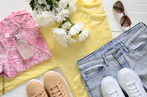 Womens fashion clothing, shoes and accessories (white and beige leather sneakers, blue jeans, yellow top (long sleeve t-shirt), pink blouse, perfume). fashion concept. Spring summer season