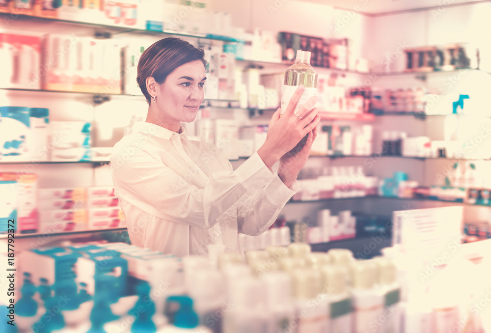 Positive woman customer browsing rows of drugs