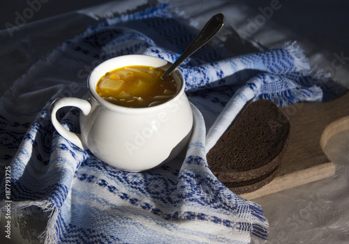 Obraz na plátne on the table a blue napkin with ornament pattern and soup tureen with yellow sou