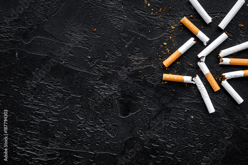 Tobacco. Scattered cigarettes on black background top view copy space