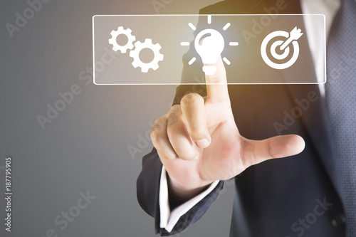 business man hand pressing a touch screen button. bulb as symbols of business man, Business concept 