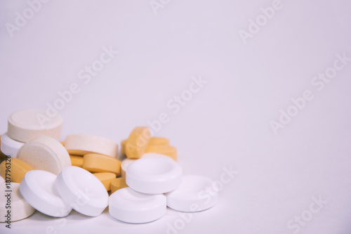 White and orange pills and vitamins on a white background. Influenza and seasonal illnesses. Medicine and pharmacy.