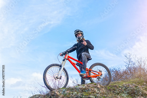 Cyclist holding a mountain bike on top of the free space. © mihakonceptcorn