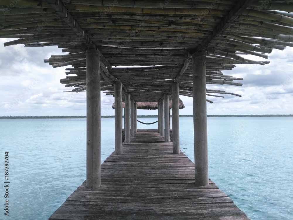Wooden palapa pier made of bamboo and view to lagoon