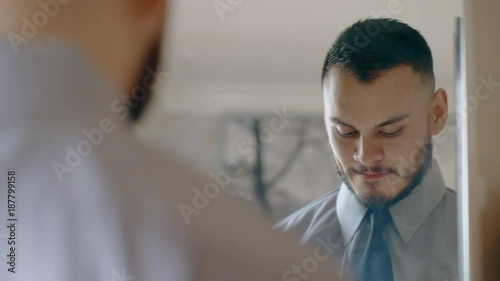 handsome hispanic man practicing speech in mirror
