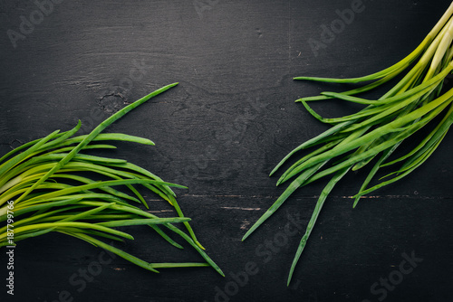 Fresh green onion on a wooden background. Top view. Free space for your text.