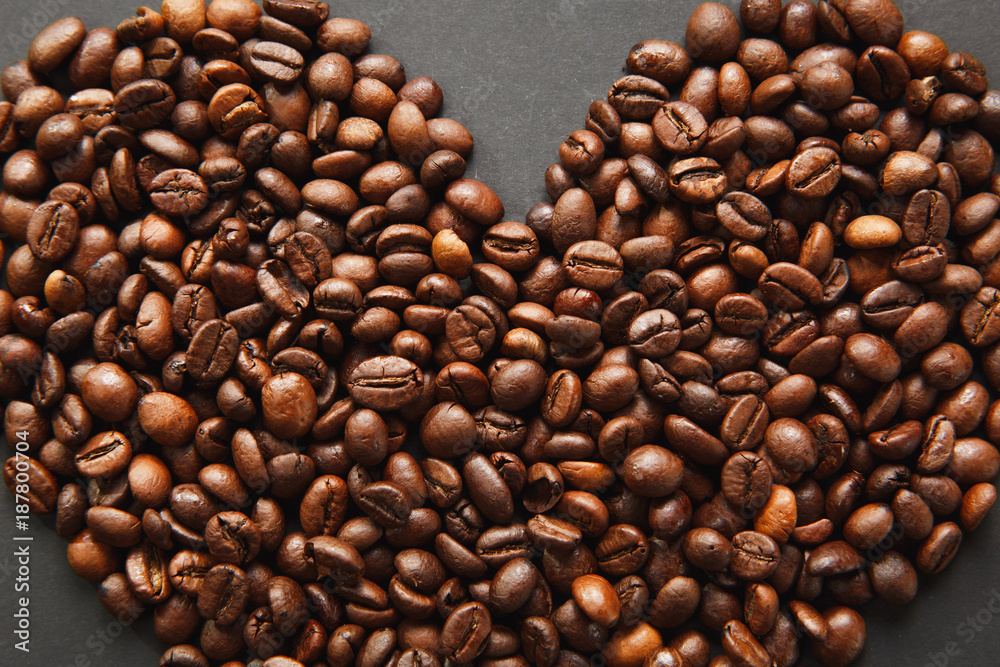 Fototapeta premium Brown coffee beans in form of heart isolated on black texture background for design, part or half. Saint Valentine's Day card on fabruary 14, holiday concept.