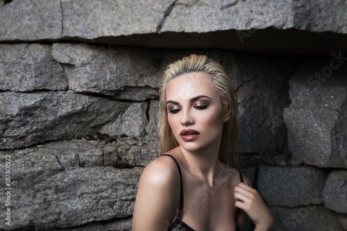 Portrait of a beautiful young woman near a stone wall © vfhnb12