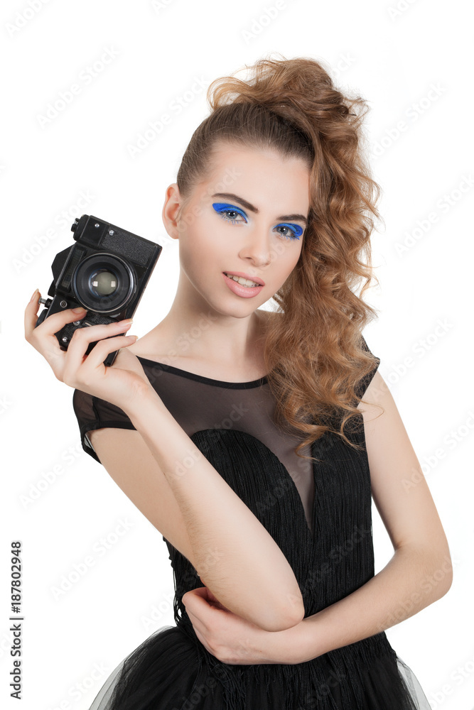 Young beautiful girl with makeup and haircut with a camera in her hand isolated on white background. Studio photography.