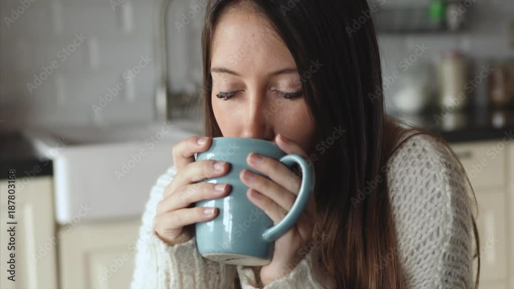 Beautiful and relaxed woman enjoys her coffee in the kitchen Beautiful and relaxed woman enjoys her coffee in the kitchen