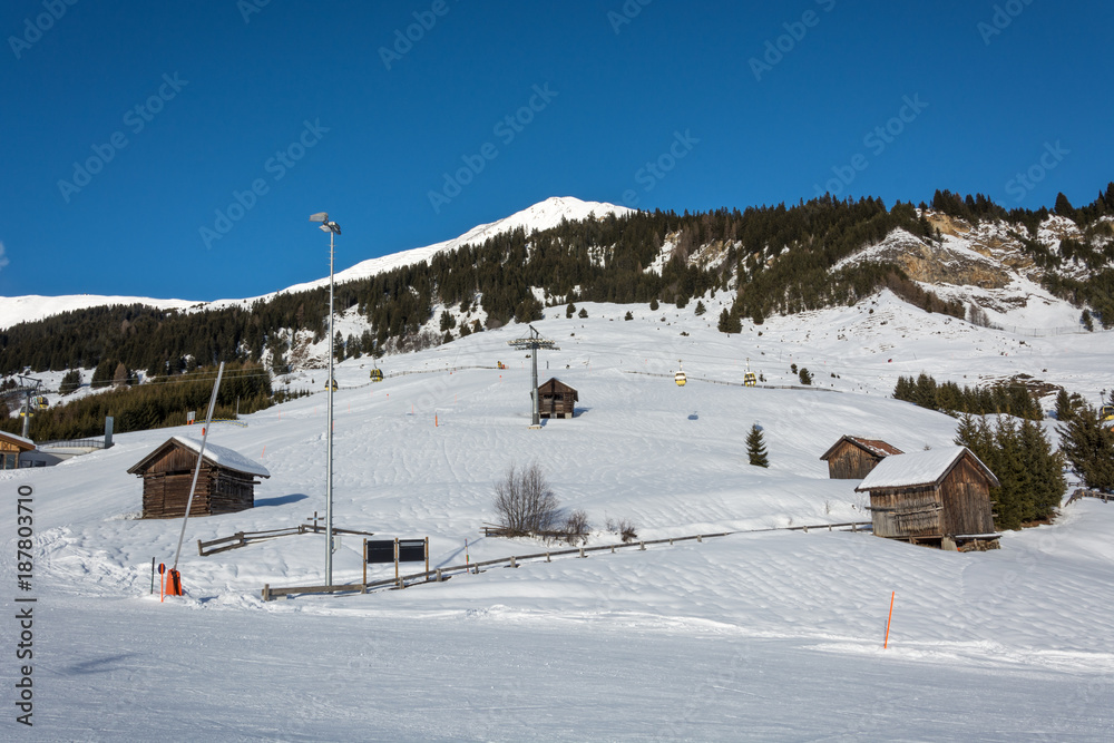 Slope and yellow gondolas in ski resort Serfaus Fiss Ladis in Austria with snowy mountains