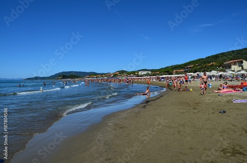 Castiglione della Pescaia, Tuscany, Italy August 17, 2014 11:00. The fine sandy beach, with tourists umbrellas and deck chairs. photo