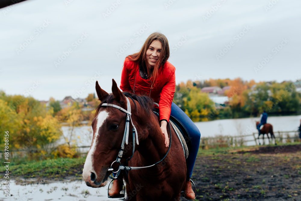Obraz premium beautiful girl rides a horse in a village in the fall