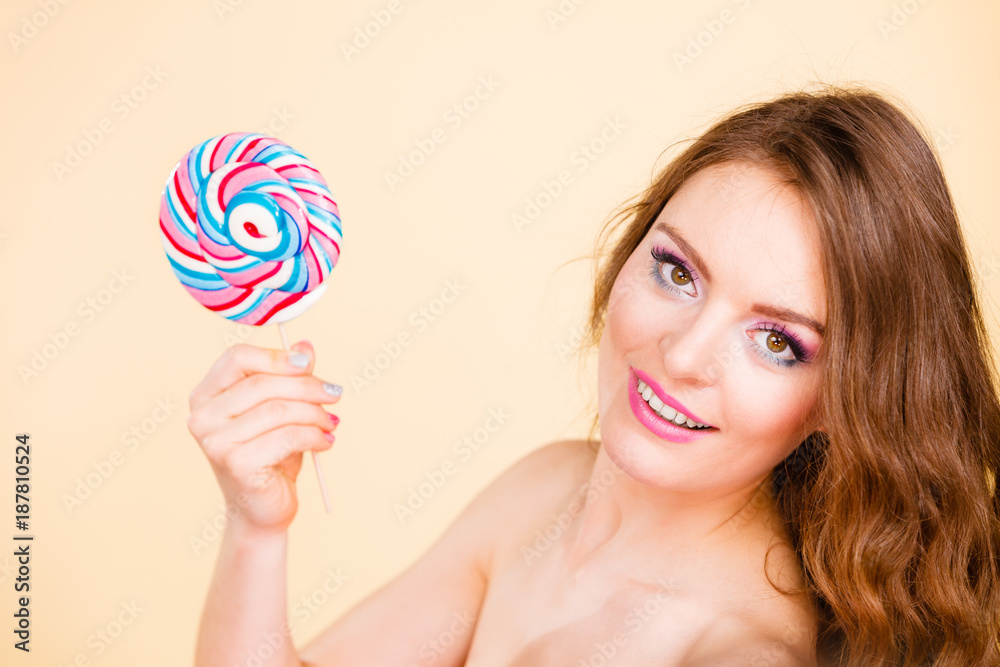 Woman holds colorful lollipop candy in hand