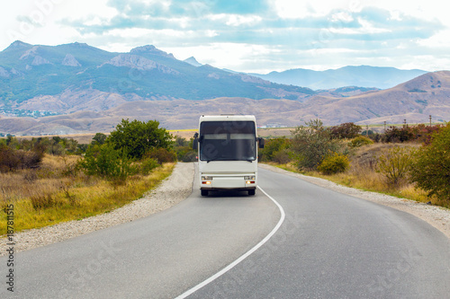 Bus is moving on a country road in a mountainous area