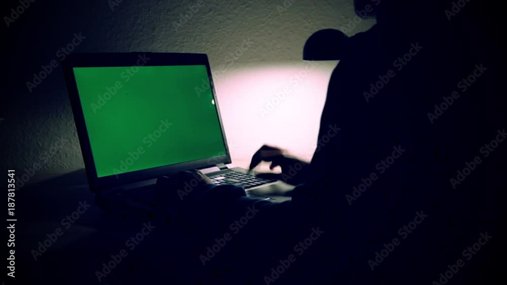Mann arbeitet nachts am Laptop im Darknet