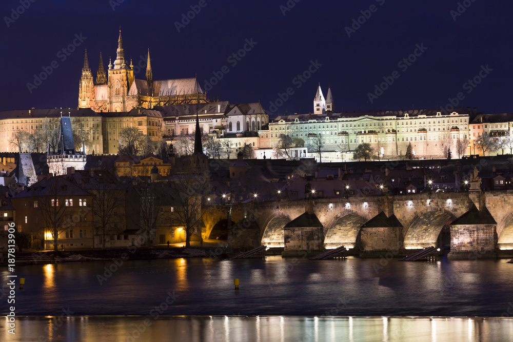 Night colorful snowy Christmas Prague Lesser Town with gothic Castle and Charles Bridge, Czech republic