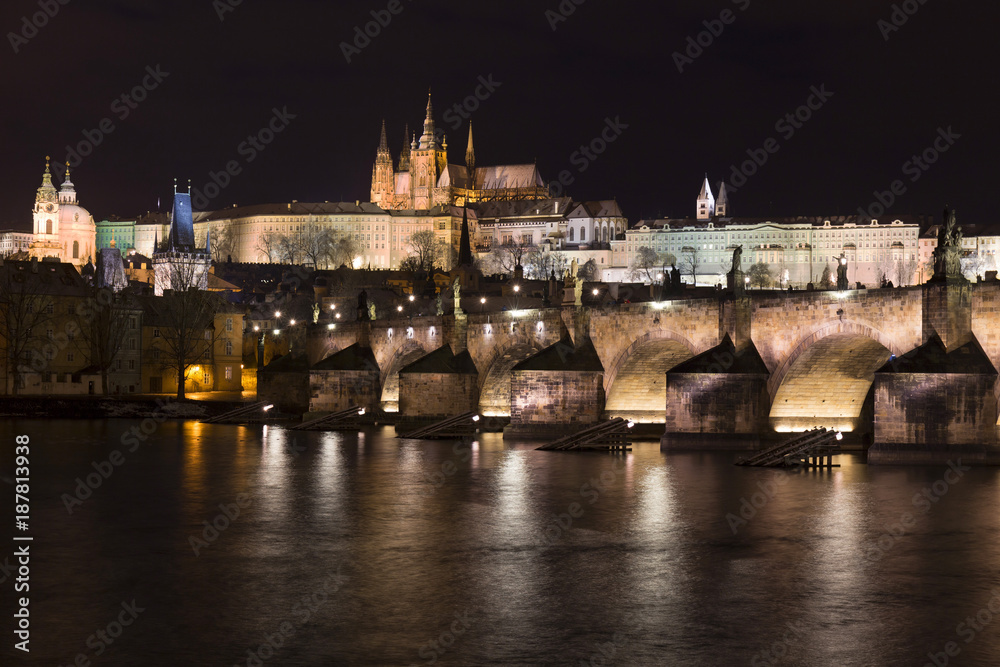 Night colorful snowy Christmas Prague Lesser Town with gothic Castle and Charles Bridge, Czech republic